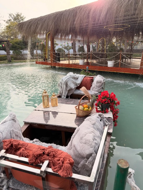 The picnic boat dressed with throws, lanterns and flowers on the pond
